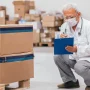 Delivery worker carrying packages in a warehouse