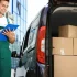Courier standing beside a delivery van loaded with packages